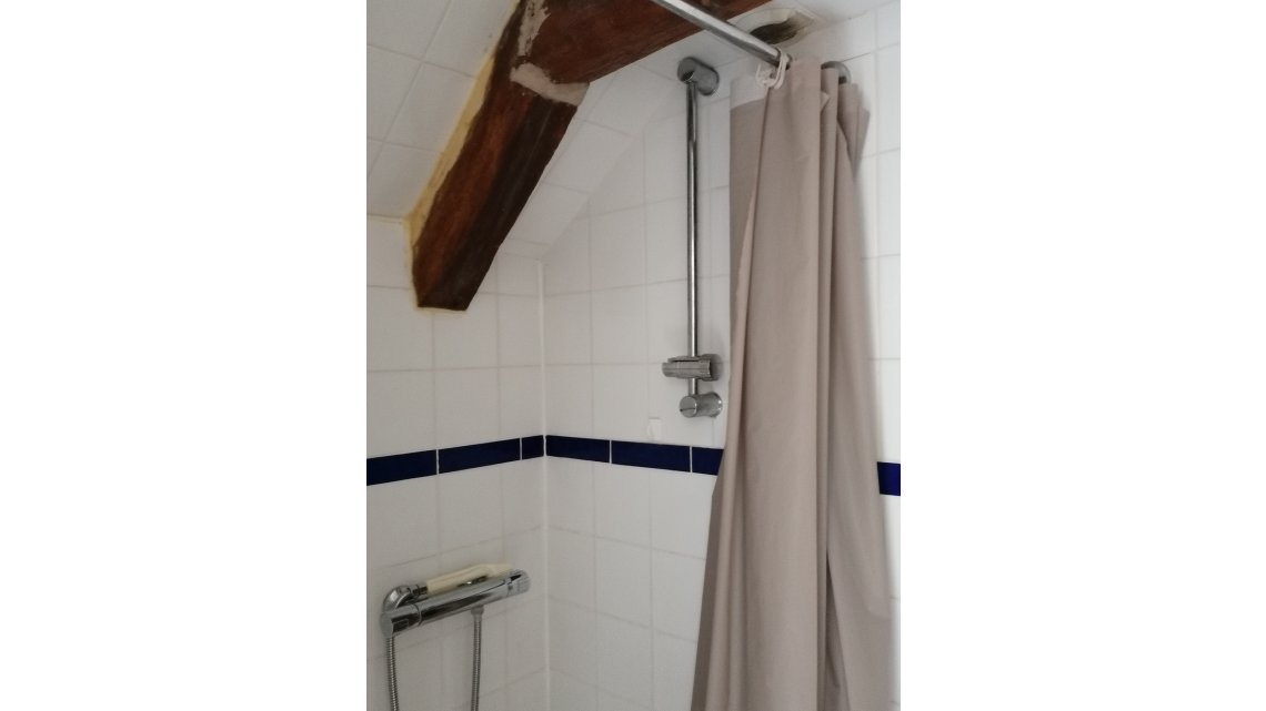 Salle d'eau avec douche et étagères