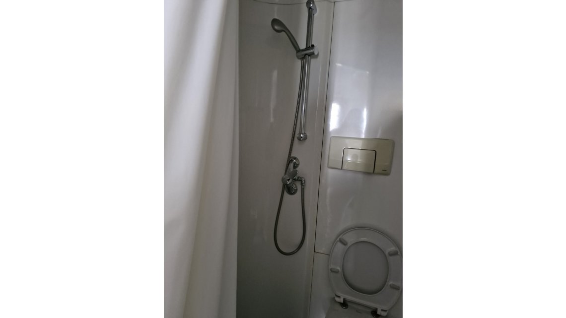 Salle de bain avec toilettes, lavabo douche et rangement 