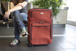 Personne assisse avec sa valise