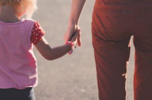 un enfant et un adulte qui se donnent la main