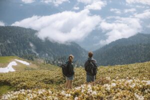 deux jeunes randonneurs à la montagne regardant les nuages, de dos