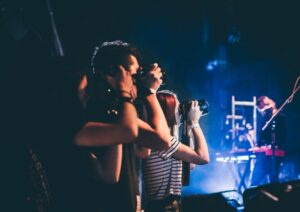 3 jeunes photographiant une scène de spectacle