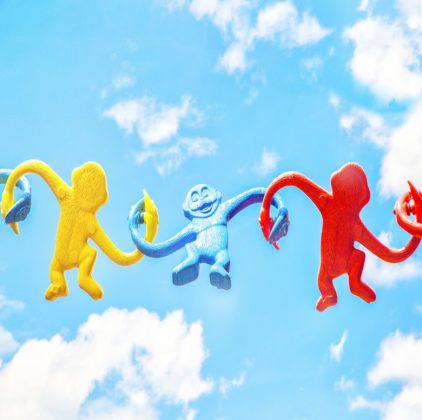 Singes coloré tout tordu qui se tiennent la main